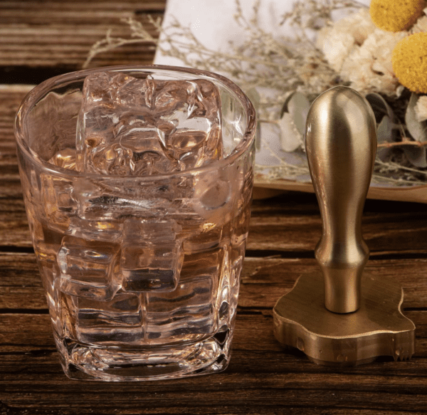 A glass of ice and a brass stamp